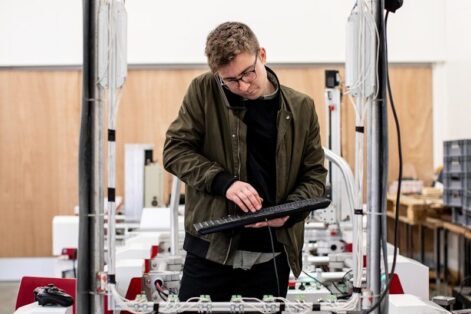 Photo by ThisisEngineering man in brown jacket using a machine