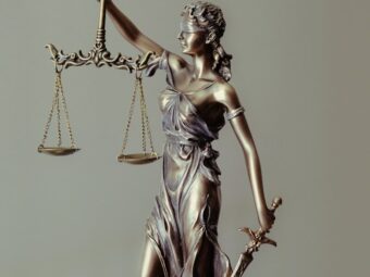 woman in gold dress holding sword figurine